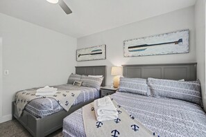 Ein Schlafzimmer mit zwei Betten, einem Deckenventilator und Bildern an den Wänden.