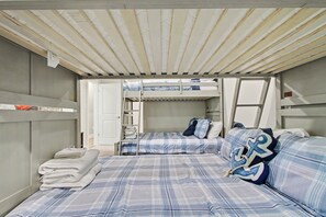 A compact room with bunk beds, a door, and a stack of towels. - New Lakefront Estate | Sleeps 34 | Private Dock (LaFollette)