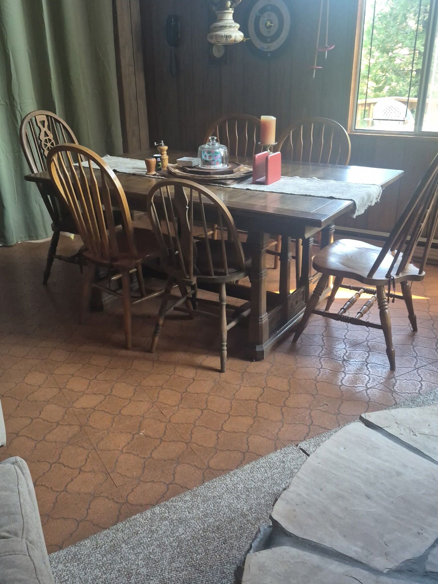 A dining table with chairs, a candle, a salt shaker, and a decorative item on the table.