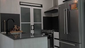 Una cucina moderna con isola centrale, elettrodomestici in acciaio inossidabile e illuminazione a sospensione.