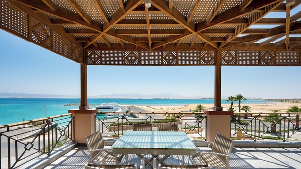 Ein überdachter Außenbereich mit Blick auf Strand und Meer.