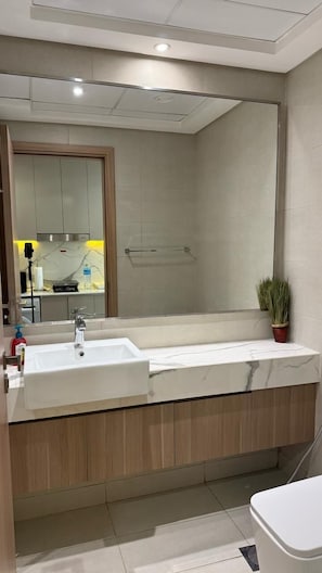 A modern bathroom with a large mirror, a double sink, and a shower area. - VESTA - Luxury Studio - Riviera (Dubai)