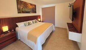 Ein Hotelzimmer mit einem Bett, Nachttischen, einem Fernseher und einem Gemälde an der Wand.
