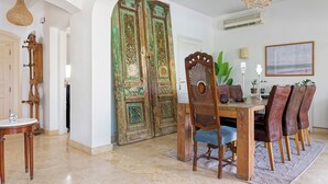 Un comedor con una mesa de madera, sillas y una puerta decorativa.