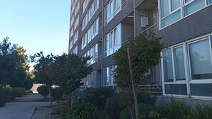 Un edificio de varios pisos con un estilo arquitectónico moderno, que cuenta con una serie de balcones y grandes ventanales.