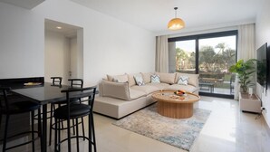 A modern living room with a sofa, coffee table, and dining area.