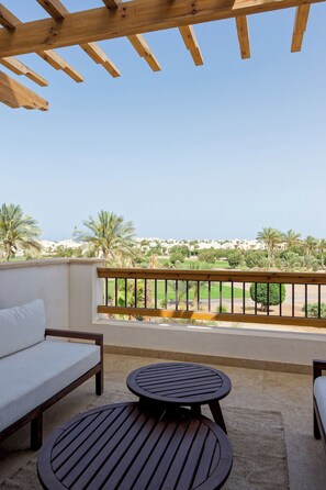 A balcony with a wooden pergola, a sofa, and two round tables. - VESTA - Luxury APT - 1BR - Fairway (El Gouna)