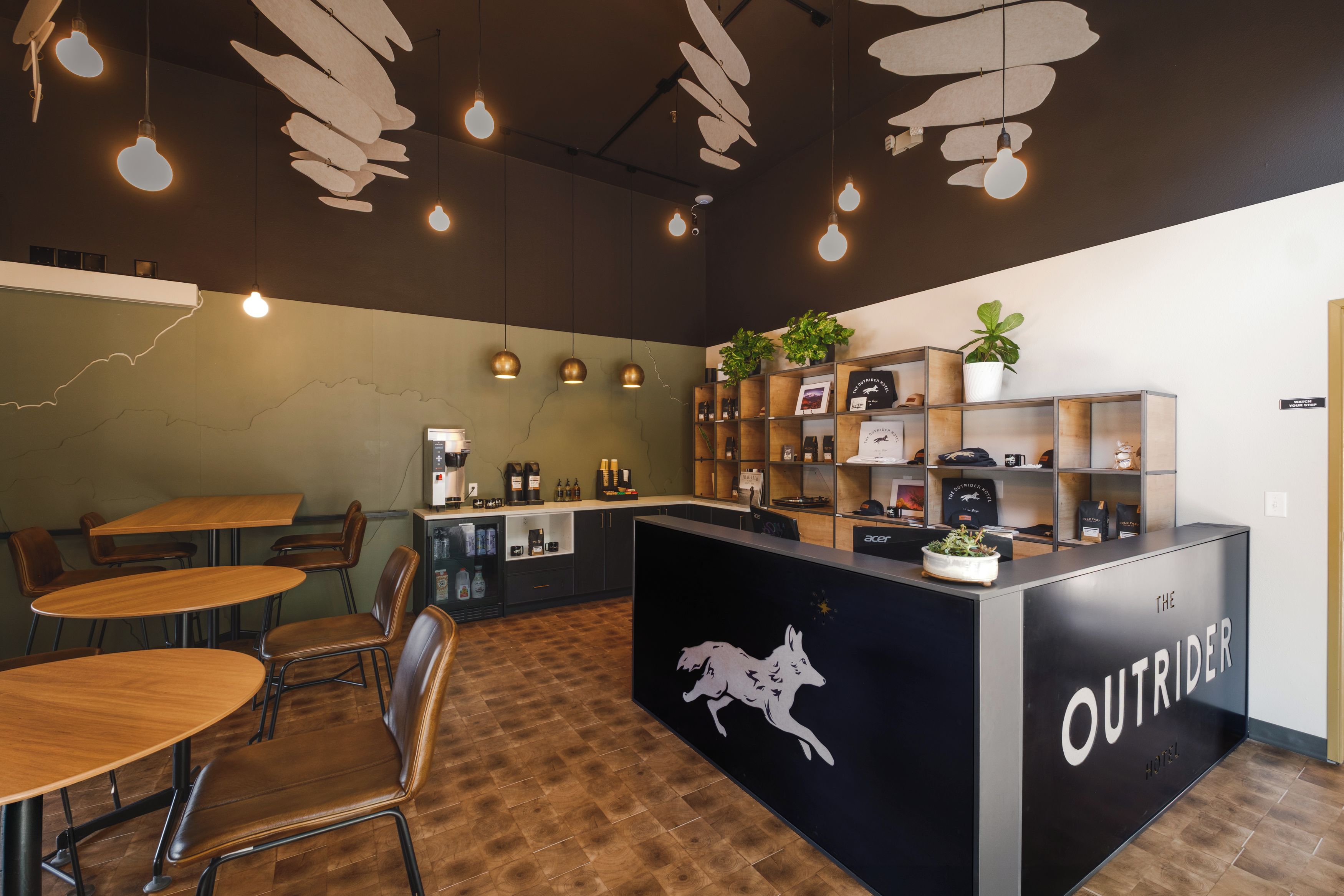 Ein Hotel-Rezeptionsbereich mit Empfangstresen, Sitzgelegenheiten und einer Kaffeemaschine.