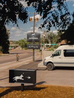 Un cartel del Hotel Outrider con una señal de flecha direccional debajo.