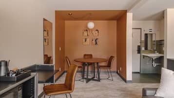A modern living room with a dining area, a kitchen, and a bathroom.