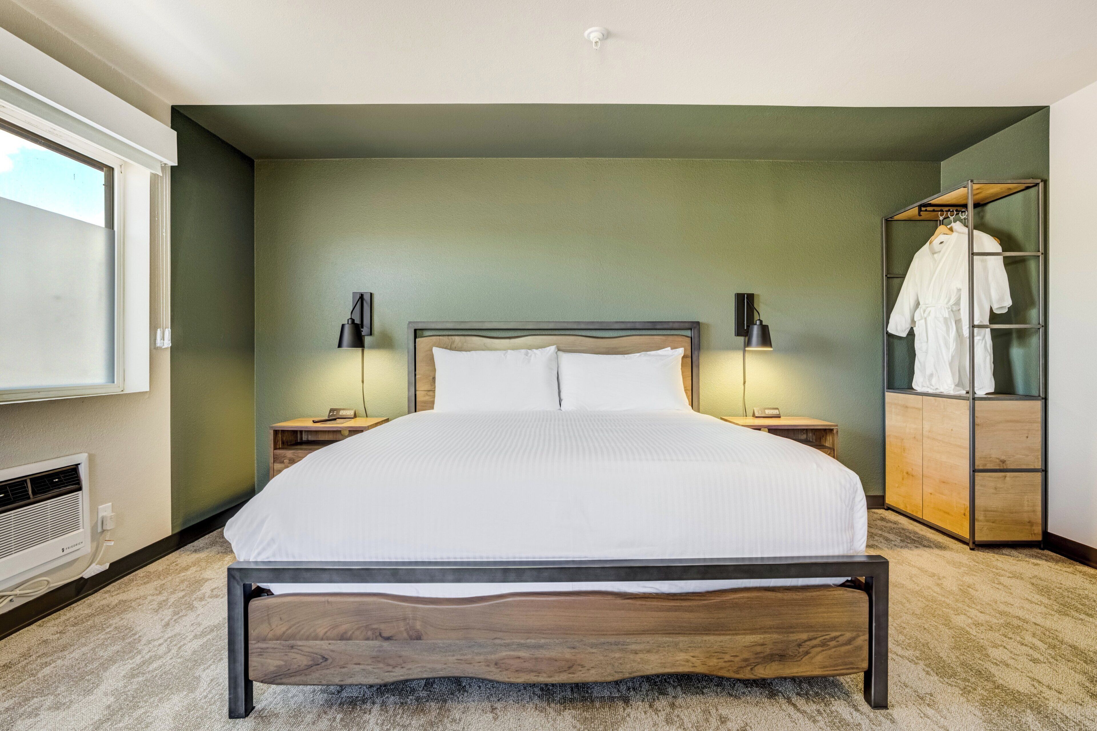 A bedroom with a bed, bedside tables, a wardrobe, and a TV.