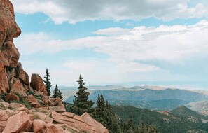 A mountainous landscape with rocky outcrops and evergreen trees. - The Outrider Hotel (Manitou Springs)