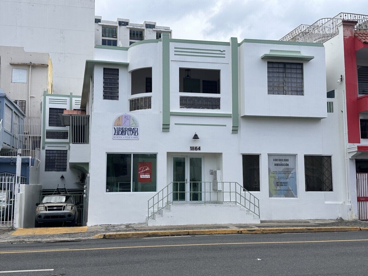 A white building with a sign for 'JBBREAS' and a number '1864' on the front.