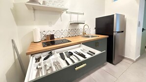Een moderne keuken met een ingebouwde lade-organizer, een roestvrijstalen koelkast en een raam boven de spoelbak.