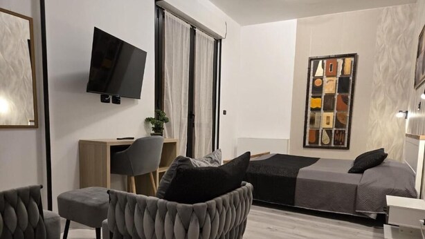 Ein modernes Schlafzimmer mit einem Bett, einem Schreibtisch und zwei Sesseln.