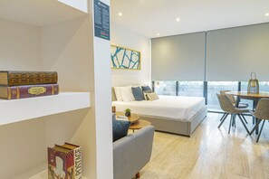 Een moderne slaapkamer met een bed, nachtkastje en uitzicht op het omliggende landschap.