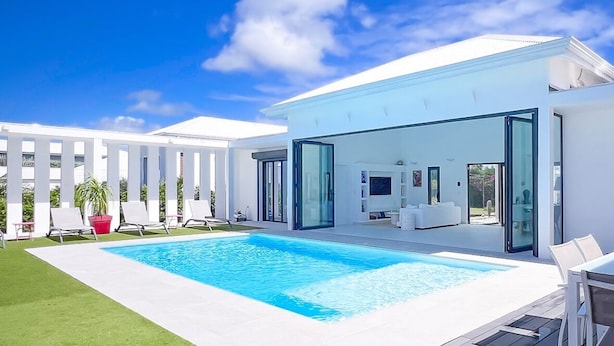 A modern house with a swimming pool, a deck, and a covered outdoor seating area. - Villa SANDI luxury and comfort - a contemporary oasis. Ideal for vacations (Saint-François)