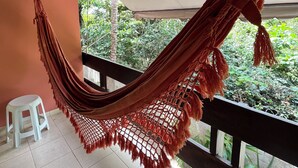 Una hamaca en un balcón con vistas a zonas verdes.