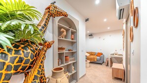 A modern living room with a large giraffe sculpture, a white arched shelving unit, and a cozy seating area with a sofa and coffee table. - Junglecavern - Private spa, unusual accommodation (Albertville)