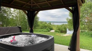 Ein Whirlpool mit Blick auf einen See und Wald.