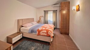 Un dormitorio con cama, mesita de noche y lámpara de pared.