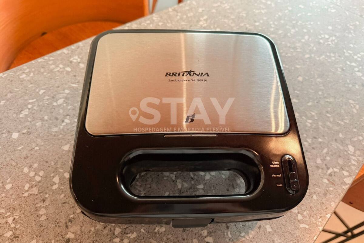 A BRITÂNIA branded device with a metallic top, a black front panel, and a control panel with buttons labeled 'Ultra Rápida,' 'Normal,' and 'Desl.'