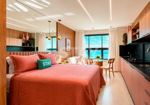 A modern hotel room with a large bed, a dining area, and a kitchen. - STAY You by Fama (Palmas)