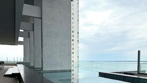 Un bâtiment moderne doté d’une piscine et offrant une vue sur la mer.