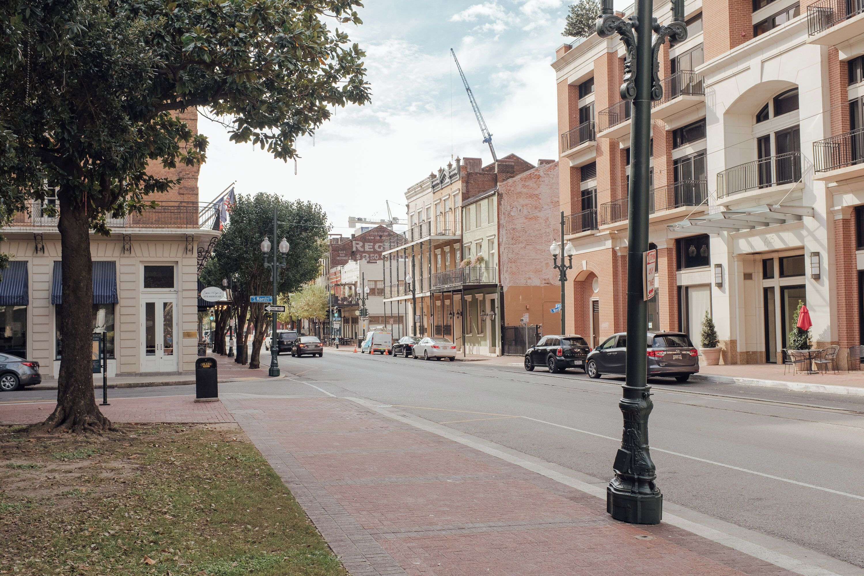 A street lined with multi-story buildings, some with balconies and storefronts.