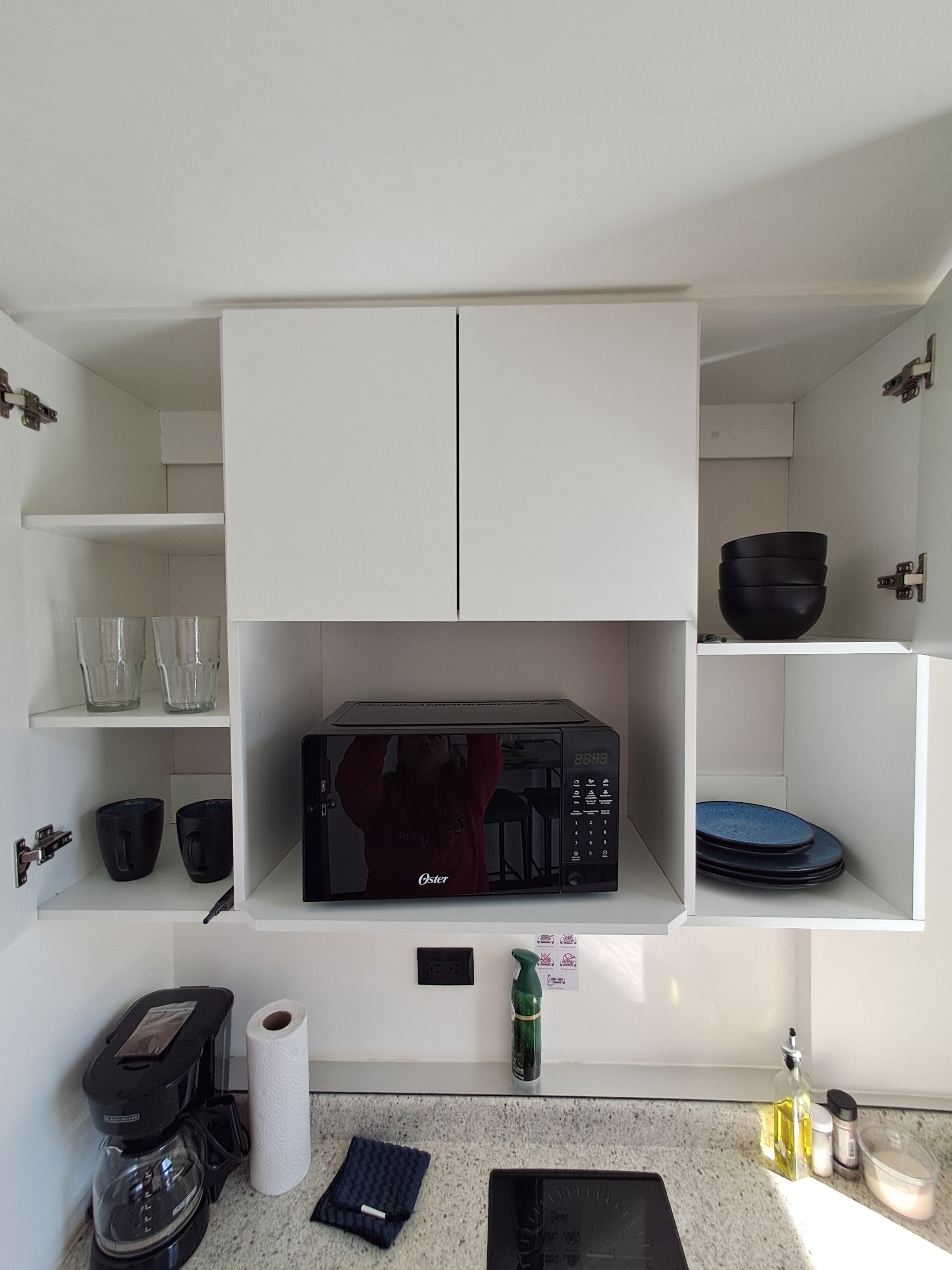 Eine Küche mit Mikrowelle, Kaffeemaschine und verschiedenen Küchenutensilien.