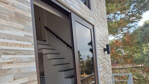 Un bâtiment moderne doté d’une grande porte vitrée qui donne sur un escalier.