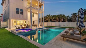 A two-story house with a swimming pool, outdoor furniture, and a well-maintained lawn. - Seaclusion l Luxury l Heated Pool l Beach (St. Augustine)