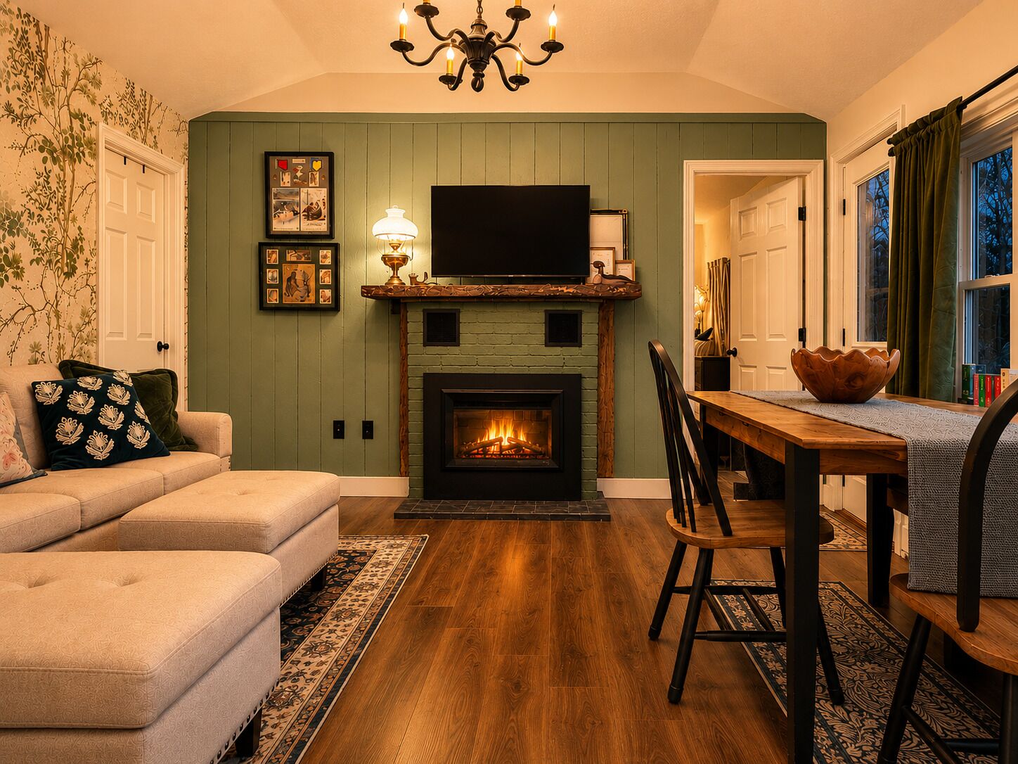 A living room with a fireplace, a sofa, a dining table, and a TV mounted above the fireplace.