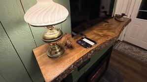 Eine Holztresen mit einer Messinglampe, einem Smartphone und einem dekorativen Gegenstand.