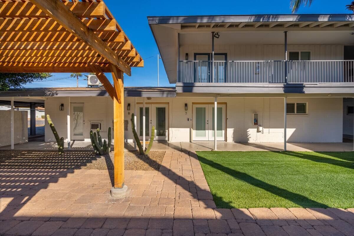 A two-story building with a covered patio area and a well-maintained lawn.