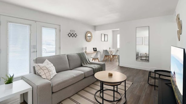 A modern living room with a grey sofa, a round coffee table, and a flat-screen TV. - King Bed near Midtown | Encanto Park (Phoenix)