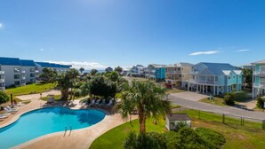 Ein Resort mit Schwimmbad, mehrstöckigen Gebäuden und einem gepflegten Rasen.