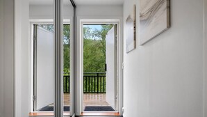 A hallway leading to a balcony with a black railing, white walls, and a framed artwork. - Spacious mountain apartment in Sirdal, near Kjerag and the Lysefjord (Agder)
