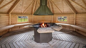 A log cabin with a central wood-burning stove, wooden beams, and a herringbone-patterned floor. - Spacious mountain apartment in Sirdal, near Kjerag and the Lysefjord (Agder)