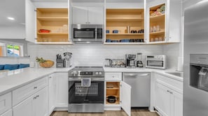 A modern kitchen with white cabinetry, stainless steel appliances, and a built-in oven. - Tranquil 3-bedroom house in charming Decatur   Near Attractions! (Decatur)