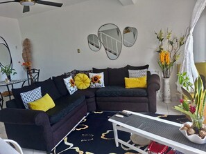 A living room with a sectional sofa, a coffee table, and decorative pillows. - The Ultimate escape on beautiful Mahogany Beach, Ocho Rios (Ocho Rios)