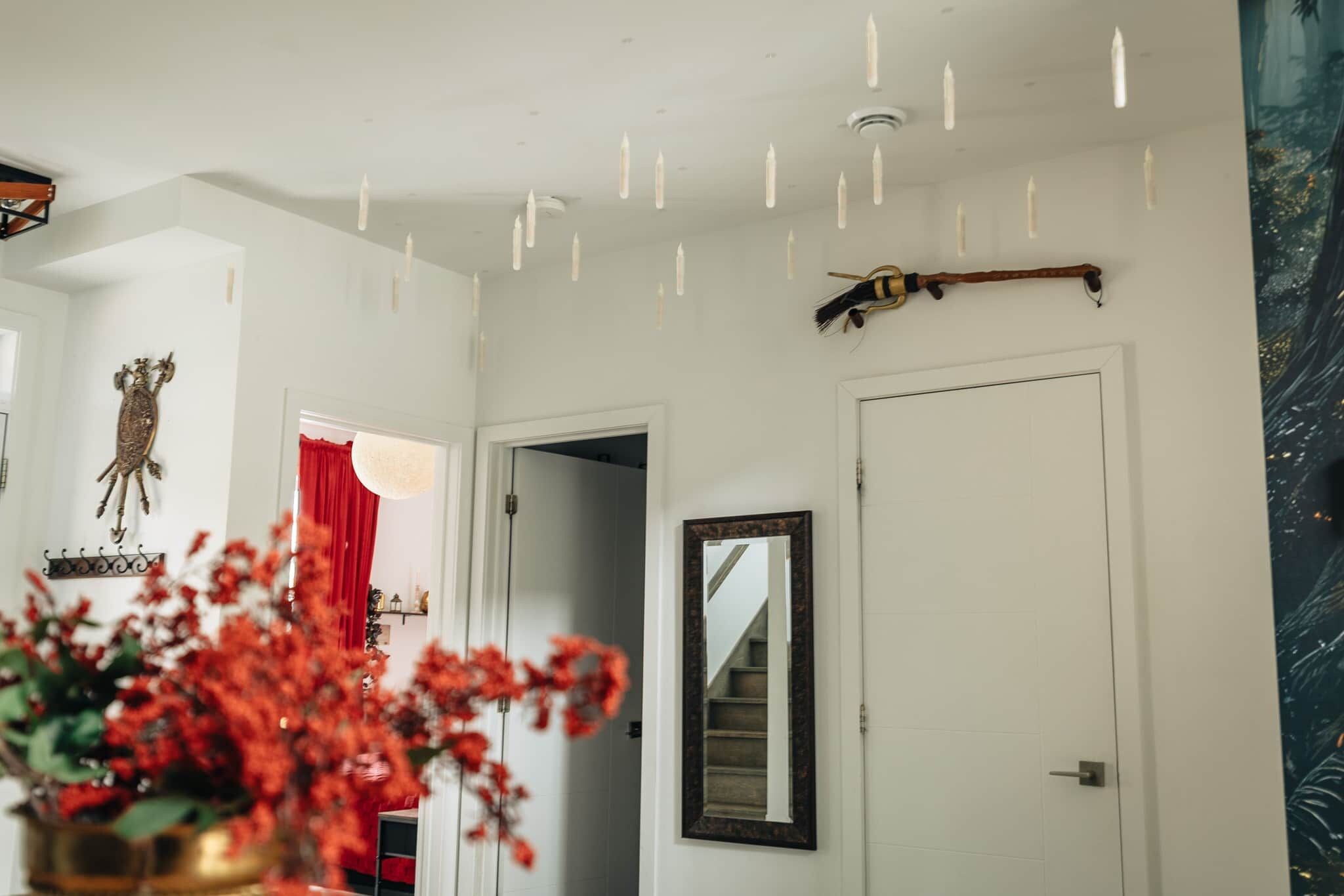 Un pasillo con un espejo, una puerta y una escalera que lleva a otra habitación.