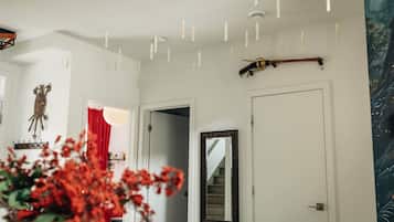 Un pasillo con un espejo, una puerta y una escalera que lleva a otra habitación.