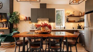 A modern kitchen with a central island, bar stools, and a large window.