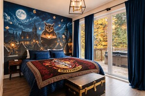 Une chambre avec un grand lit, une fresque murale représentant un ciel étoilé et une vue sur le feuillage automnal.