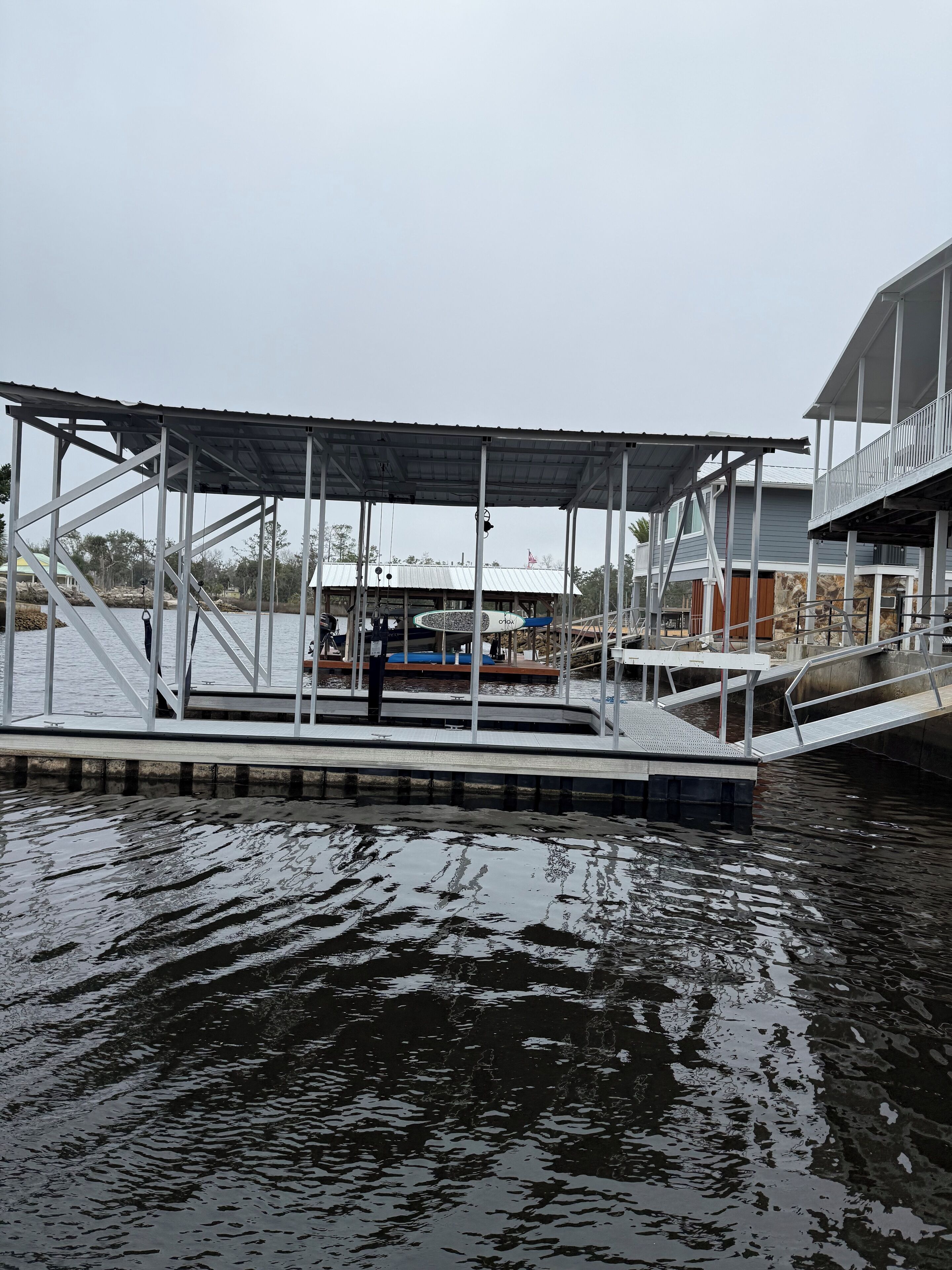 Un muelle con pasarela techada, un bote y un edificio de fachada de piedra.