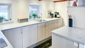 A modern kitchen with light wood cabinets, a granite countertop, a sink, and a coffee maker. - Cozy home in Nykøbing M with WiFi (Nykøbing M)