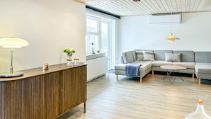 A modern living room with a wooden console table, a grey sofa, and a round coffee table. - Cozy home in Nykøbing M with WiFi (Nykøbing M)