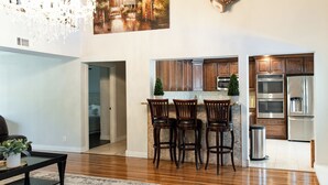 Eine moderne Küche mit Holzausstattung, einem Edelstahlkühlschrank und einem Essbereich mit Holztisch und Stühlen.