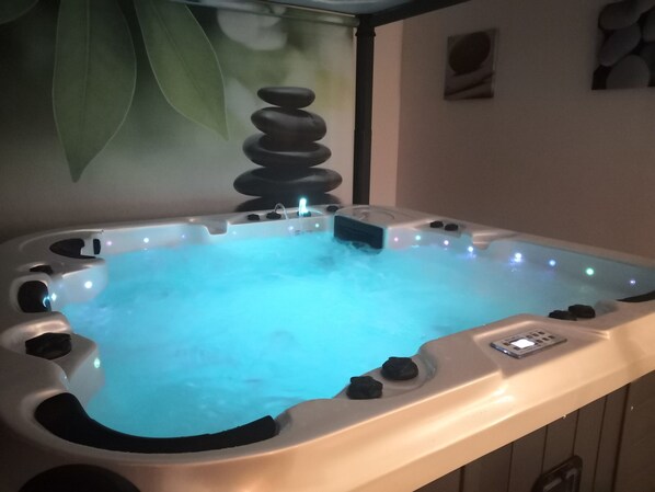 A hot tub with a control panel and a water feature.
